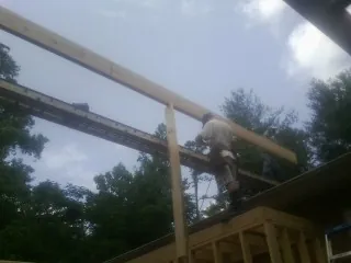 Carpenter setting a ridge beam over a new addition frame — Ice Dam Removal by Roofing Brothers in Mechanicville