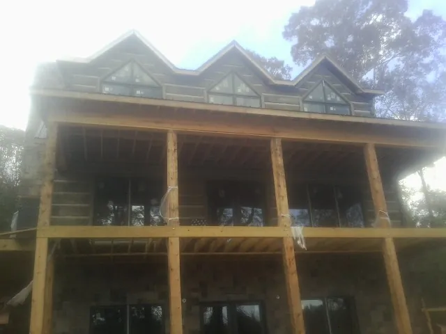 Dormers and porch framing on a large log home under construction — Roof Coating work by our crew in Mechanicville