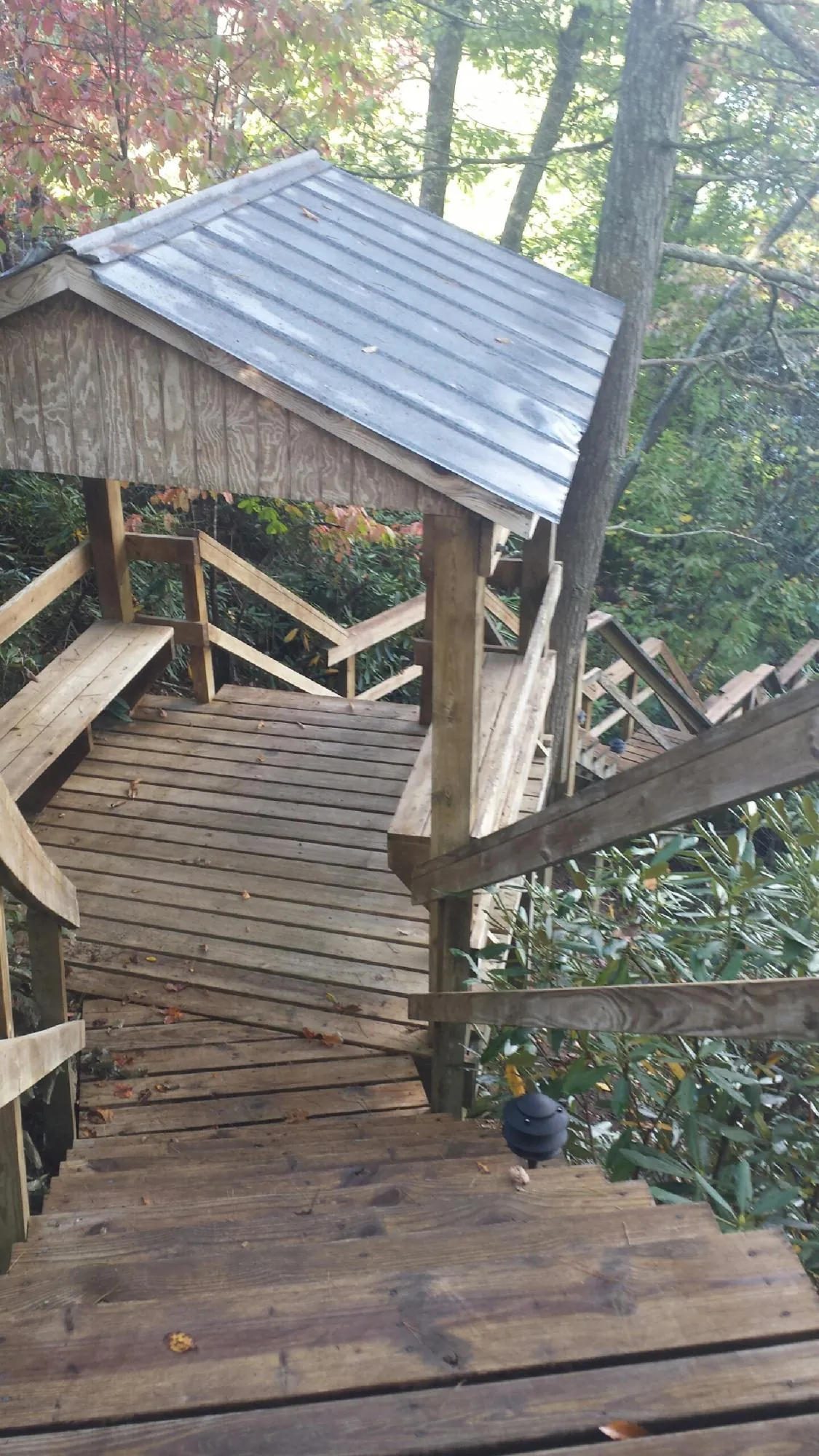 Metal roofed shelter over wooden steps on a wooded walkway — Skylight Repair & Installation work by our crew in Mechanicville