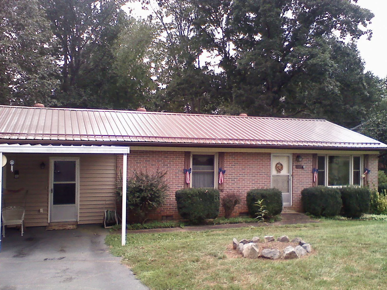Bronze metal roof and carport on a brick ranch home — Roof Repair work by our crew in Mechanicville